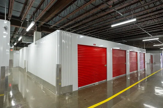 Long indoor storage hallway with rows of secure units and reflective flooring